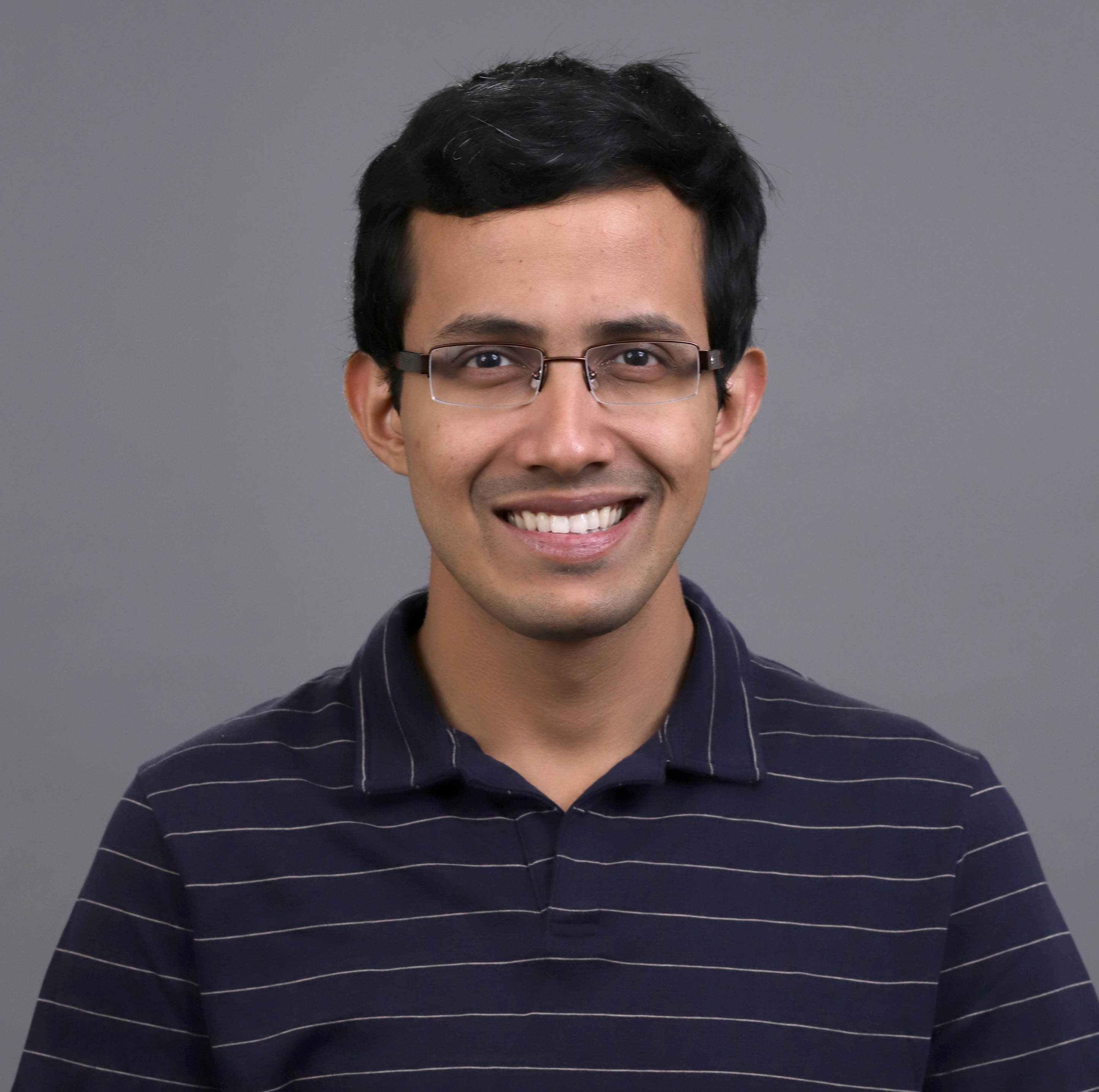 Anirudh Sivaraman in front of a gray backdrop.